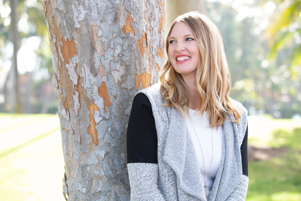 welcome to Orly's Light Coaching standing outside with her back against a tree